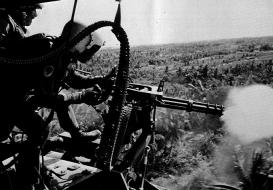Een helikopterschutter neemt de jungle onder vuur tijdens de Vietnamoorlog